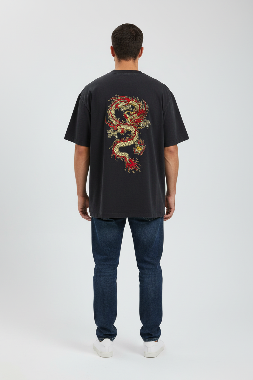 Person wearing a black t-shirt with a colorful dragon design on the back, standing against a white background.