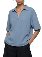 Person wearing a blue polo shirt with a white background