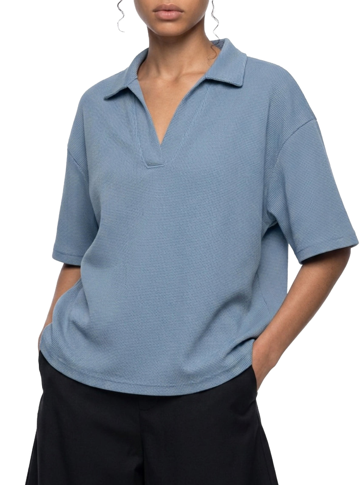 Person wearing a blue polo shirt with a white background